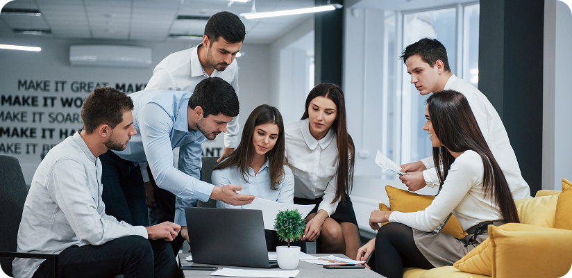 Team collaborating around laptop